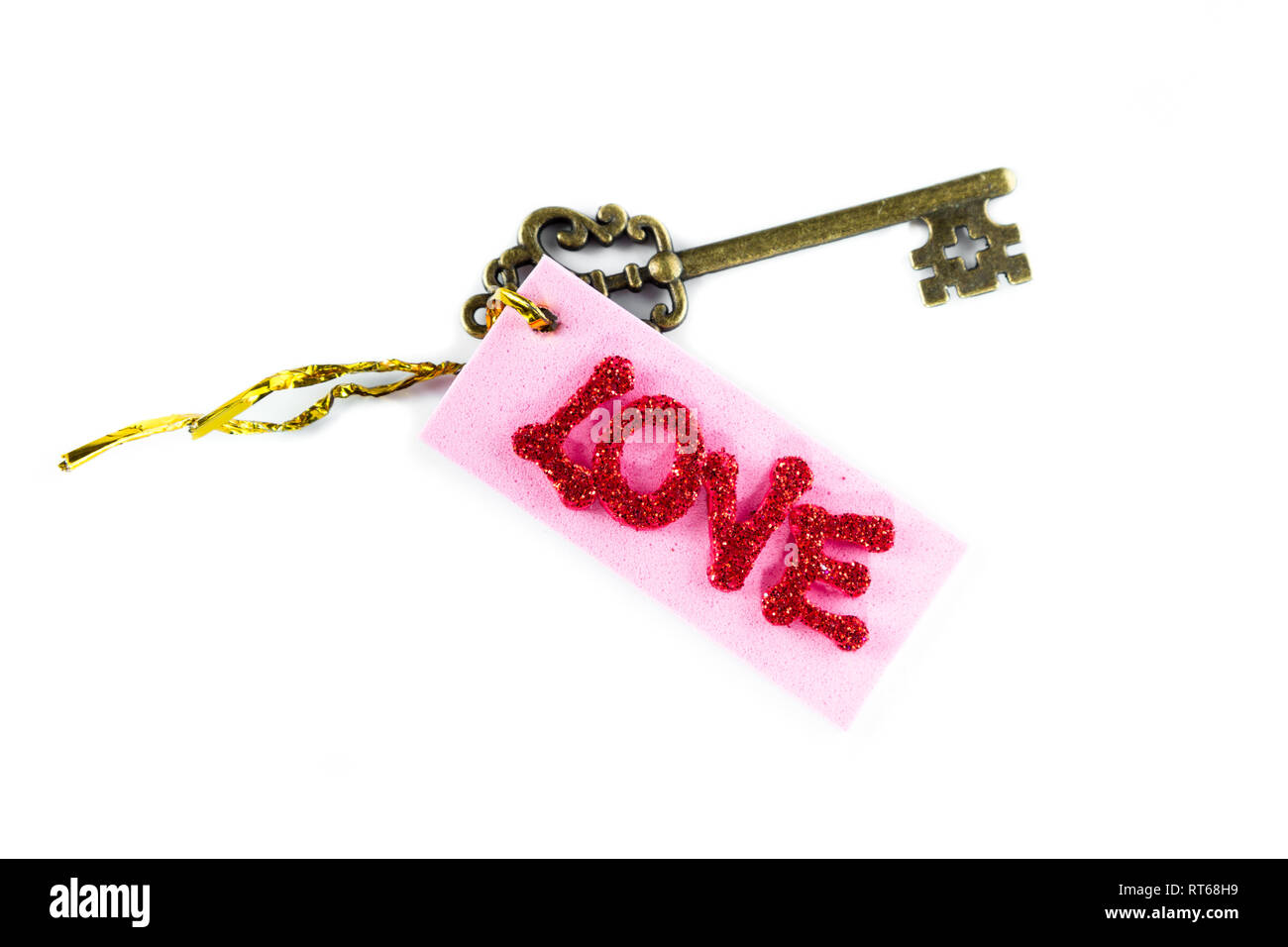 In prossimità di un tasto ornamentali con un tag e la parola amore in glitter lettere isolate su uno sfondo bianco Foto Stock