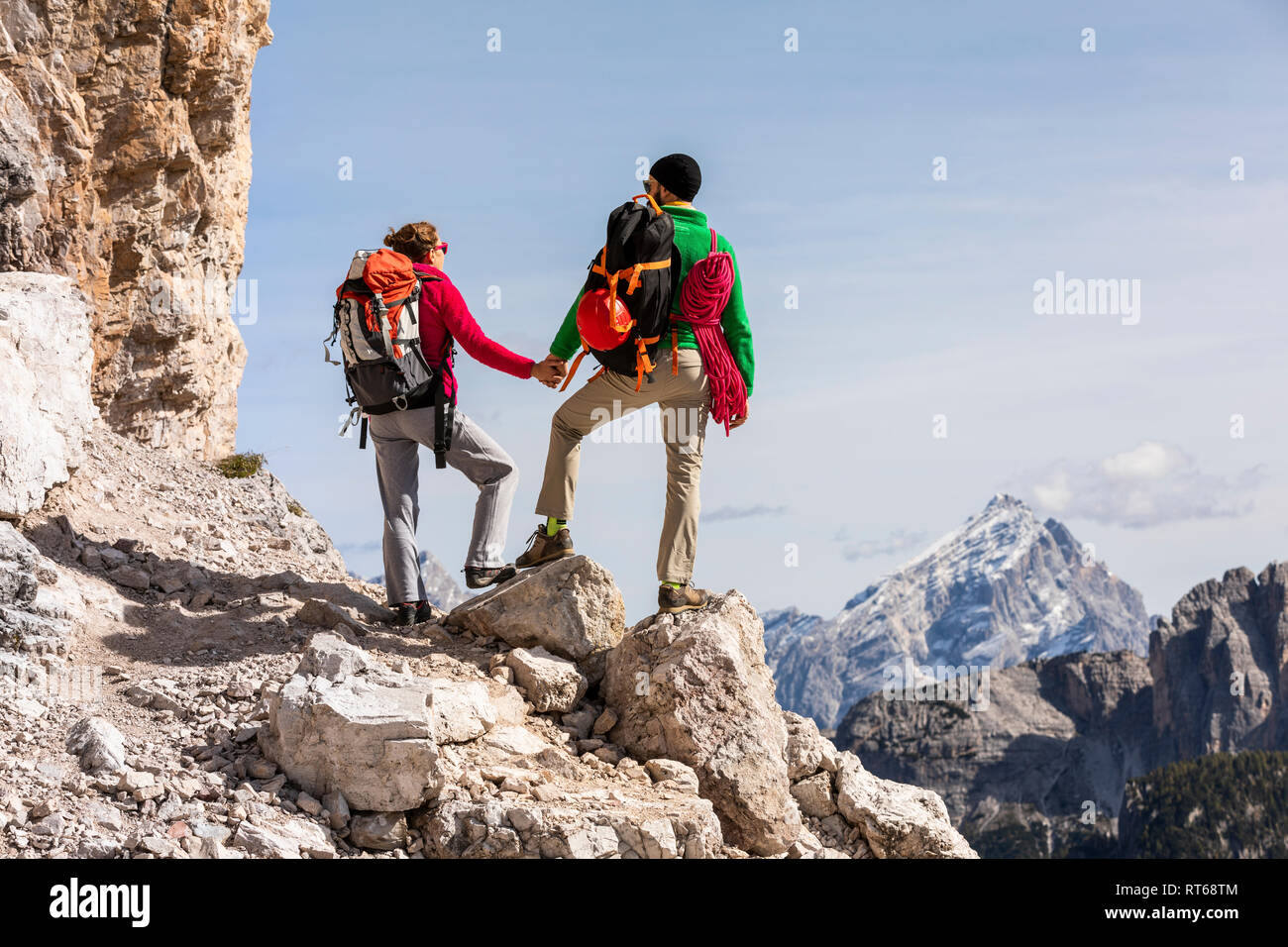 L'Italia, Cortina d'Ampezzo, giovane con corda e arrampicata attrezzature per mano e cercando di visualizzare Foto Stock