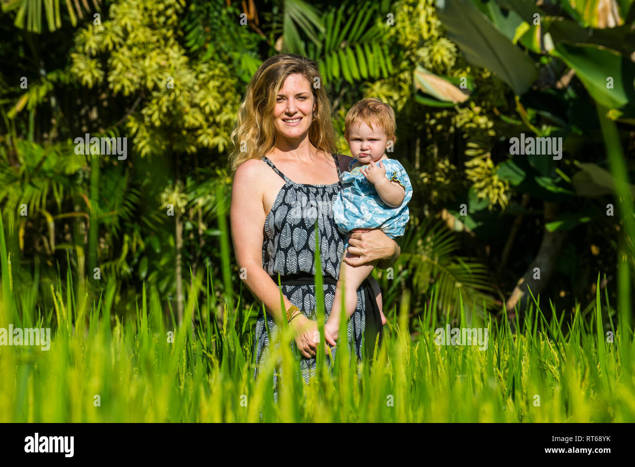 Indonesia Bali Ubud, Donna con la sua bambina in risaie. Foto Stock