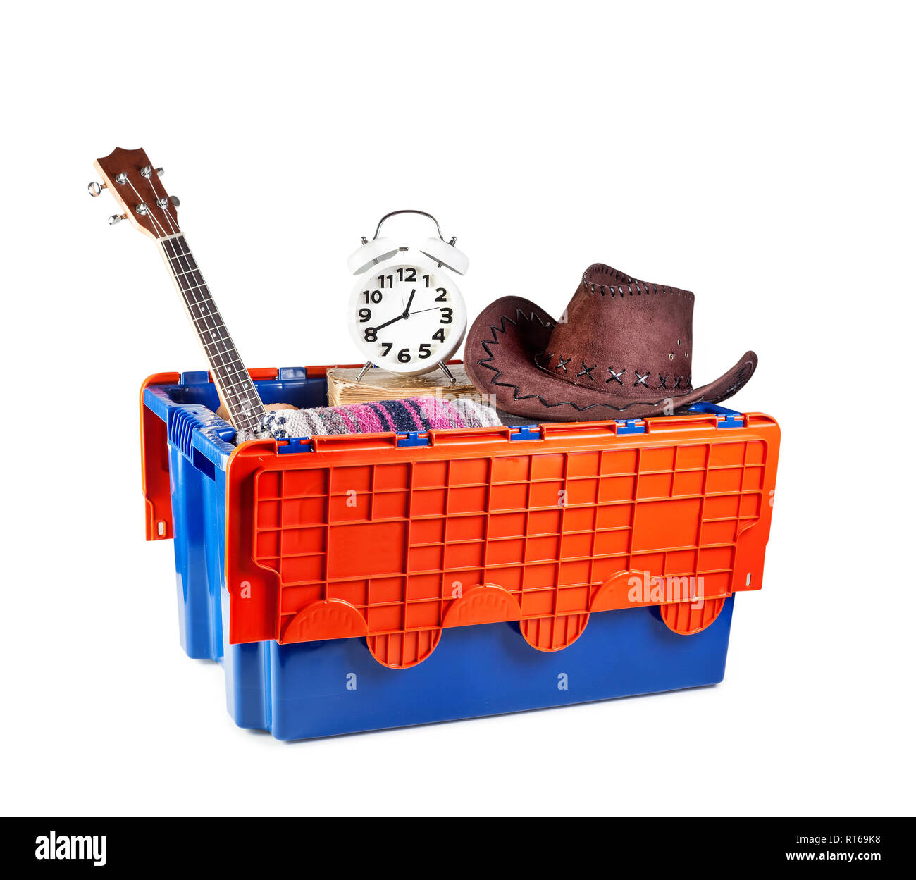 Scatola di movimentazione con chitarra, allarme e vestiti in un nuovo appartamento a sfondo bianco. Immobiliare di concetto. Foto Stock