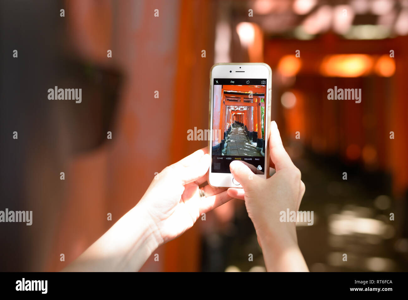 La donna utilizza smart phone per fotografare i cancelli Torii di Sacrario scintoista Fushimi Inari taisha a Kyoto, Giappone. Fushimi Inari taisha-sul Monte Inari è la testa Foto Stock