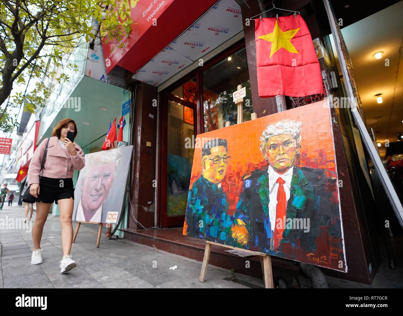 Hanoi, Vietnam. 28 Feb, 2019. Una donna cammina ultimi dipinti di U.S. Presidente Trump e leader della Corea del nord Kim è visibile sul visualizzatore in corrispondenza di una galleria negozio durante il secondo la Corea del Nord per gli Stati Uniti Vertice nella città capitale di Hanoi. Credito: Christopher Jue/ZUMA filo/Alamy Live News Foto Stock