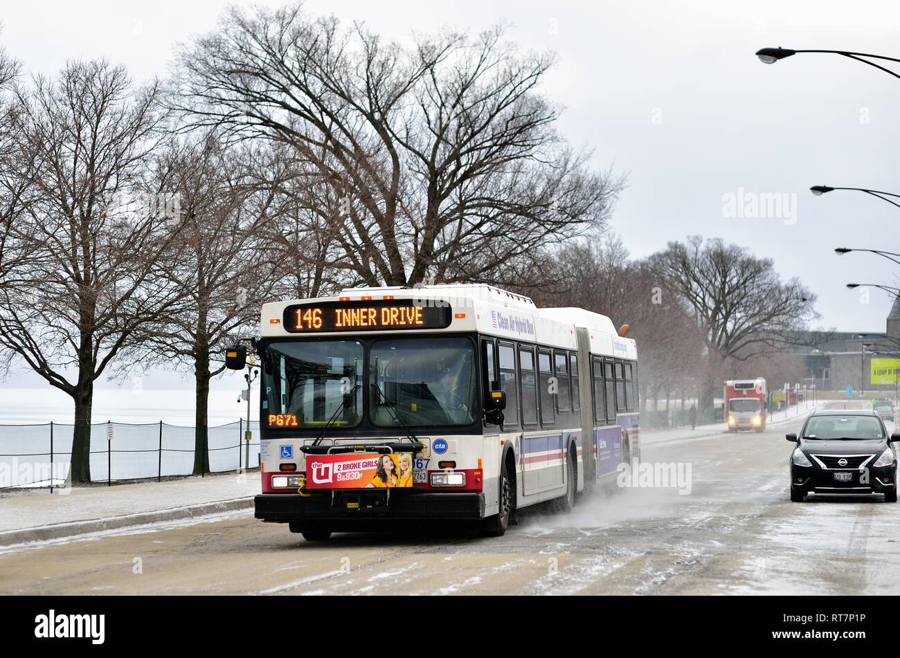 Chicago, Illinois, Stati Uniti d'America. Un CTA bus fino a calci la neve come passa lungo il Chicago Museum Campus appena a sud del loop. Foto Stock