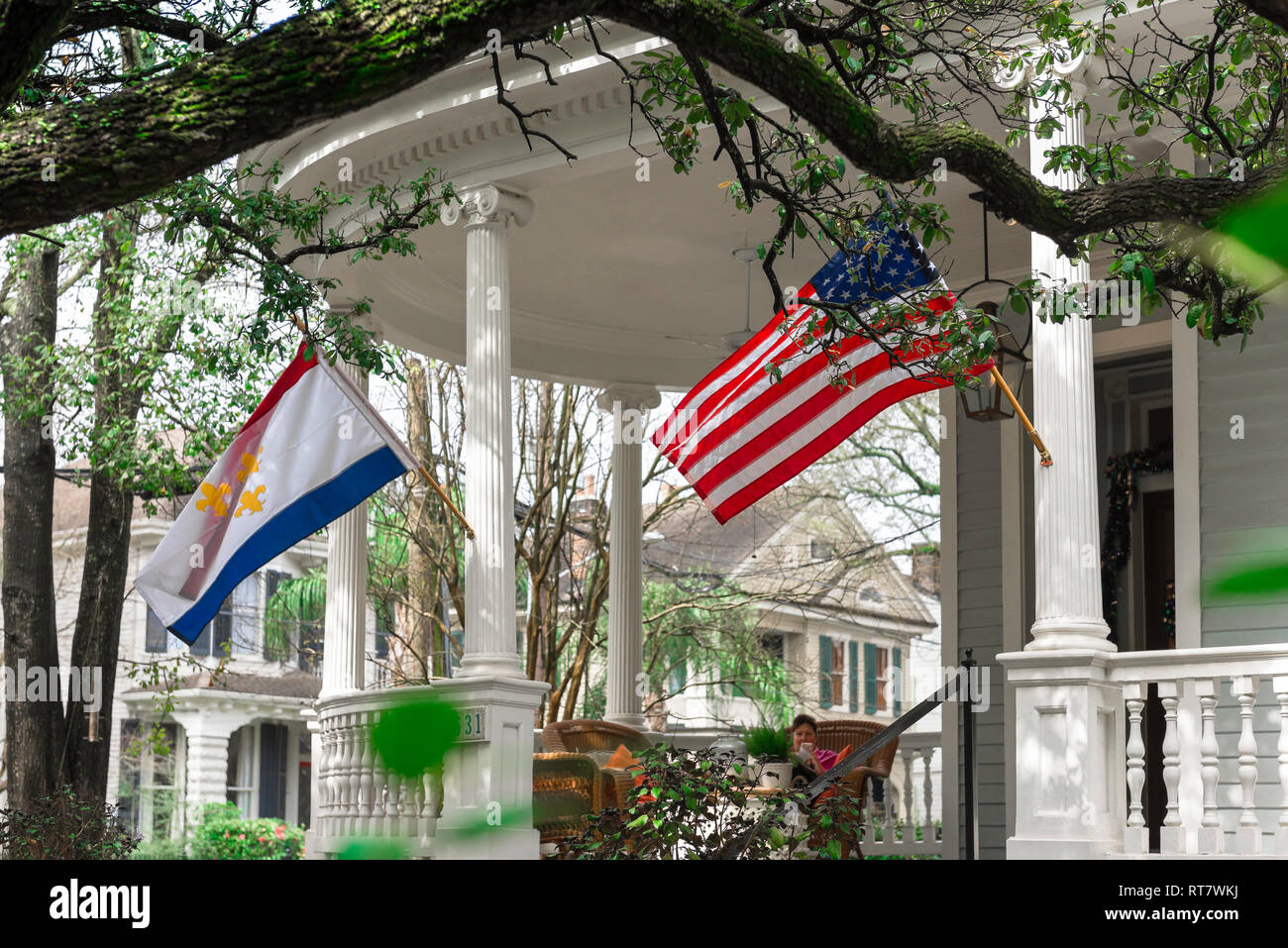 Garden District di New Orleans, vista tipica di un portico con colonne e bandiere che sventolano nella sistemazione di giardino residenziale quartiere di New Orleans, STATI UNITI D'AMERICA Foto Stock