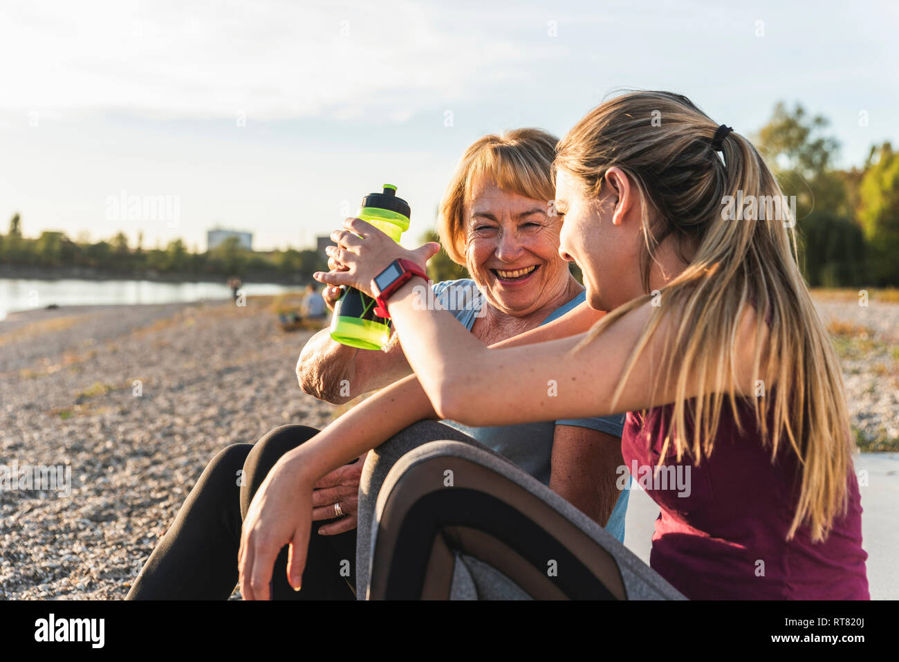 Nonna e nipote di prendere una pausa dopo aver esercitato sul fiume Foto Stock