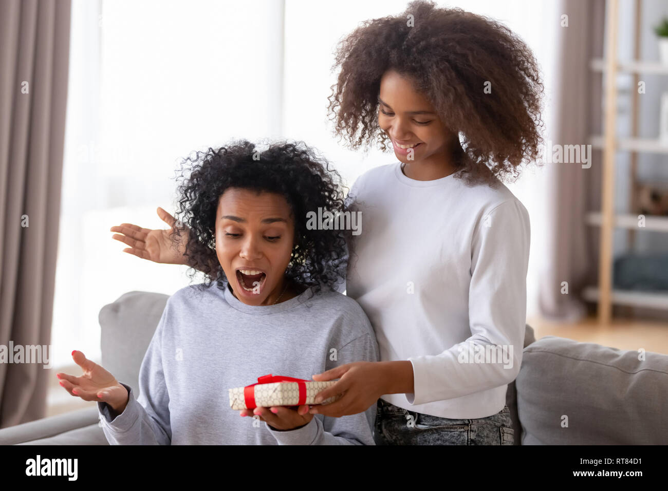 Figlia africana Rendere sorpresa di Madre tanto amata Foto Stock
