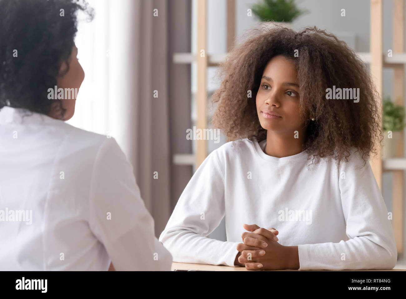 Teen visitando la clinica medica di ascolto lavoratore seduto a medici office Foto Stock