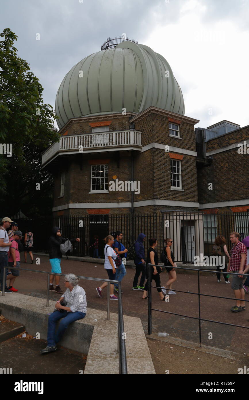 I turisti a piedi passato il grande storico edificio equatoriale con un telescopio cupola all'Osservatorio Reale di Greenwich a Londra, Regno Unito. Foto Stock