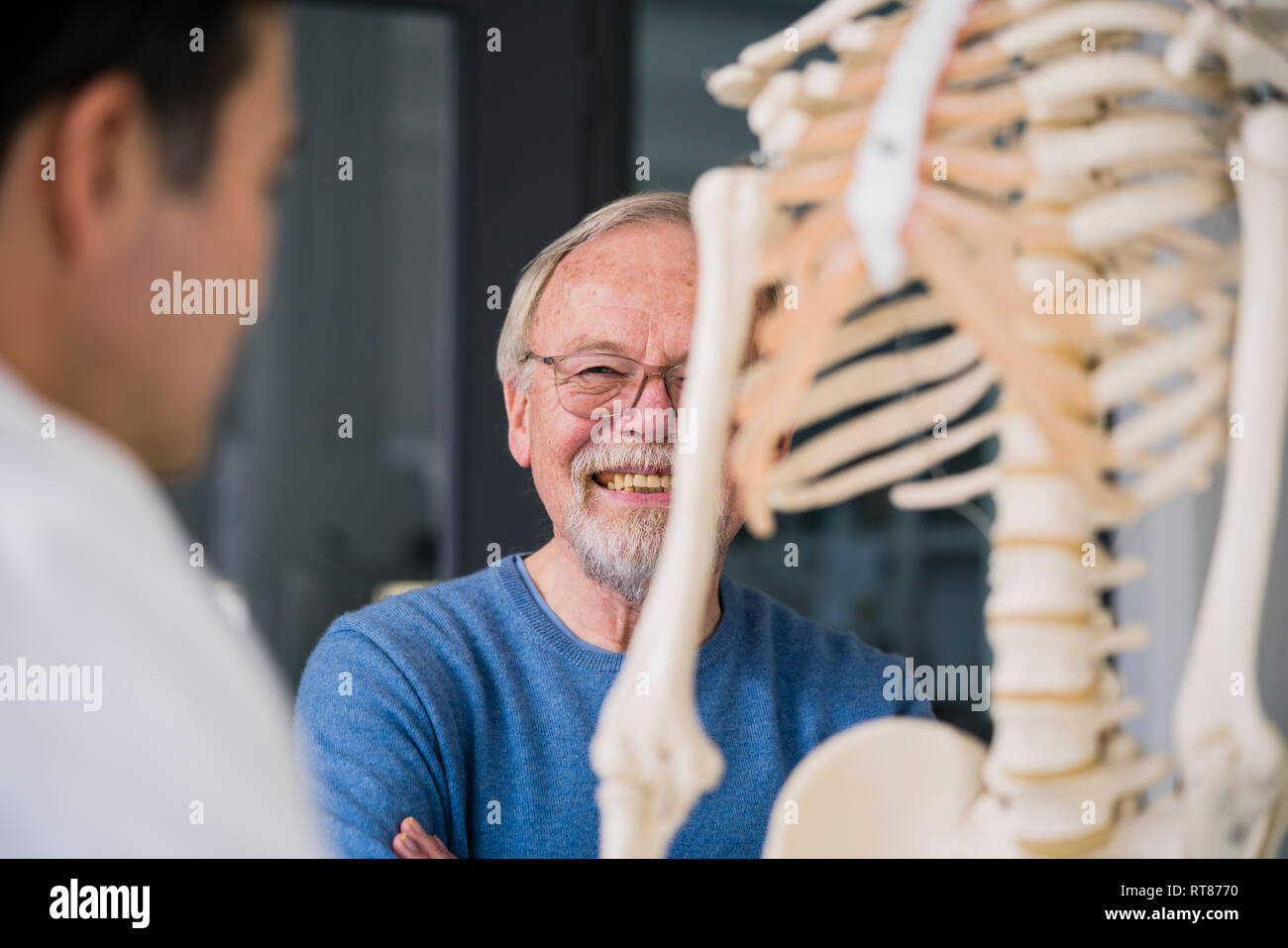 Sorridente senior con paziente medico nella pratica medica con modello anatomico Foto Stock