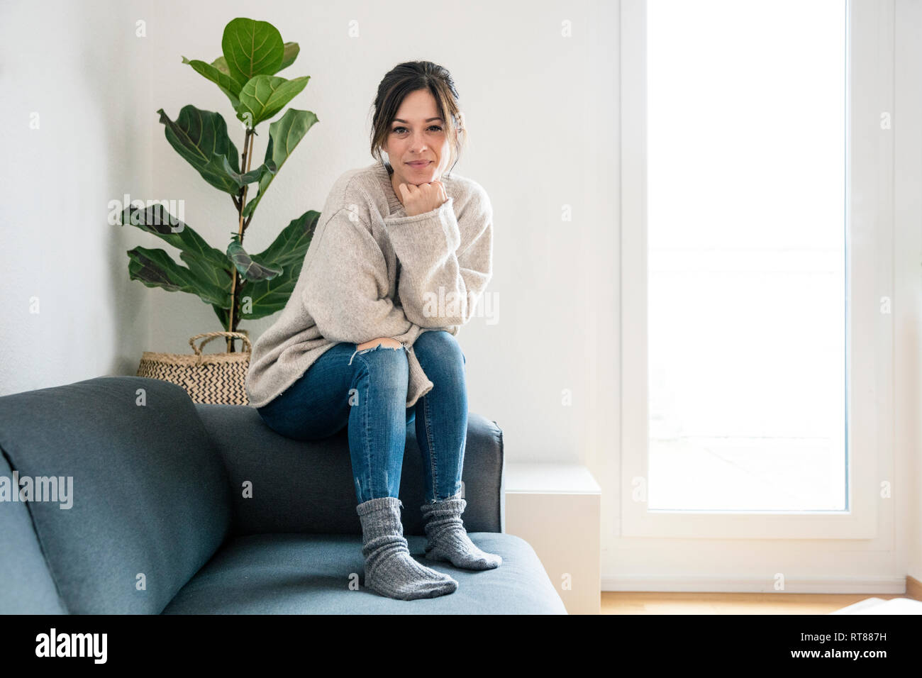La donna seduta sul suo lettino, guardando la fotocamera Foto Stock