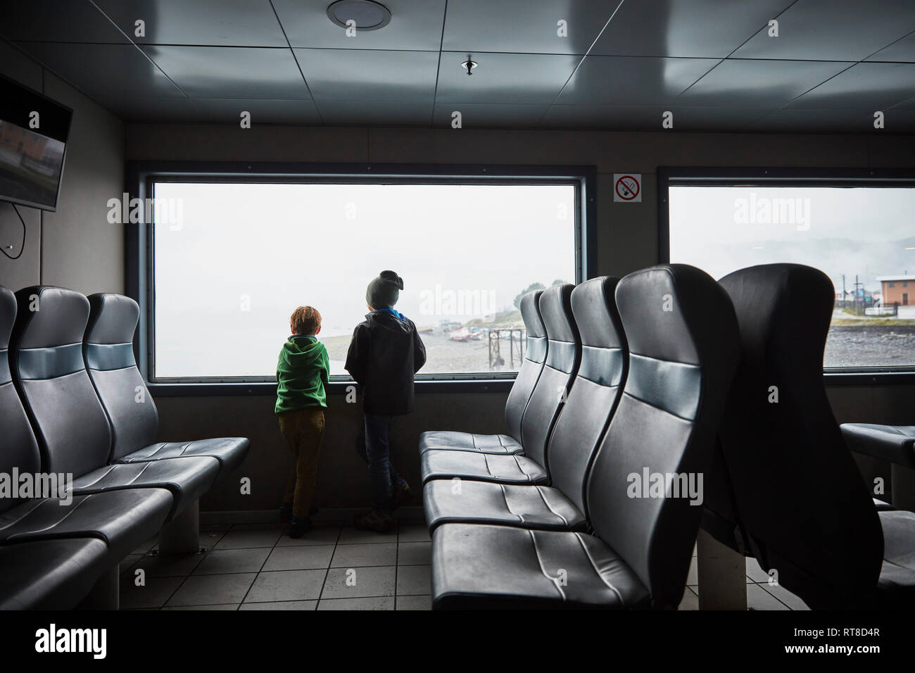 Il Cile, Puerto Montt, due ragazzi guardando fuori della finestra di un traghetto Foto Stock