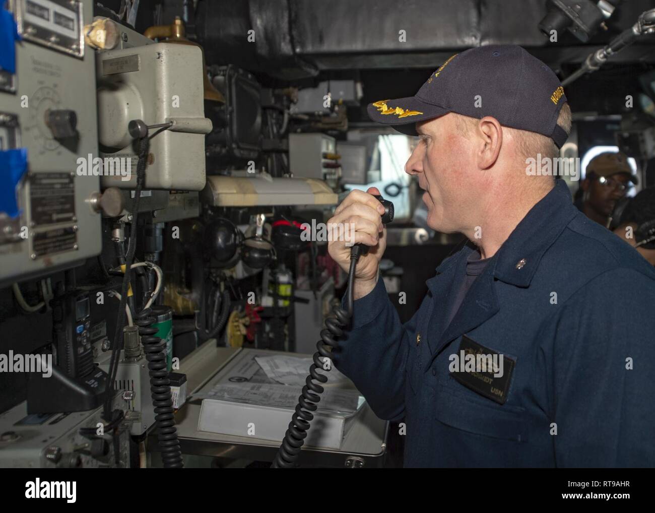 Stati Uniti 5TH FLOTTA AREA DI OPERAZIONI (GEN. 30, 2019) - Cmdr. Steve Schmidt, comandante della Whidbey Island-classe dock anfibio sbarco nave USS Fort McHenry (LSD 43), rende un annuncio sul 1MC. Fort McHenry è parte dell'anfibio Kearsarge pronto il gruppo e con il ventiduesimo imbarcato Marine Expeditionary Unit, è distribuito negli Stati Uniti Quinta Flotta area di operazioni a sostegno di operazioni navali per garantire stabilità marittimo e la sicurezza nella regione centrale di collegamento del Mediterraneo e del Pacifico attraverso l'Oceano Indiano occidentale e tre strategici punti di strozzatura. Foto Stock
