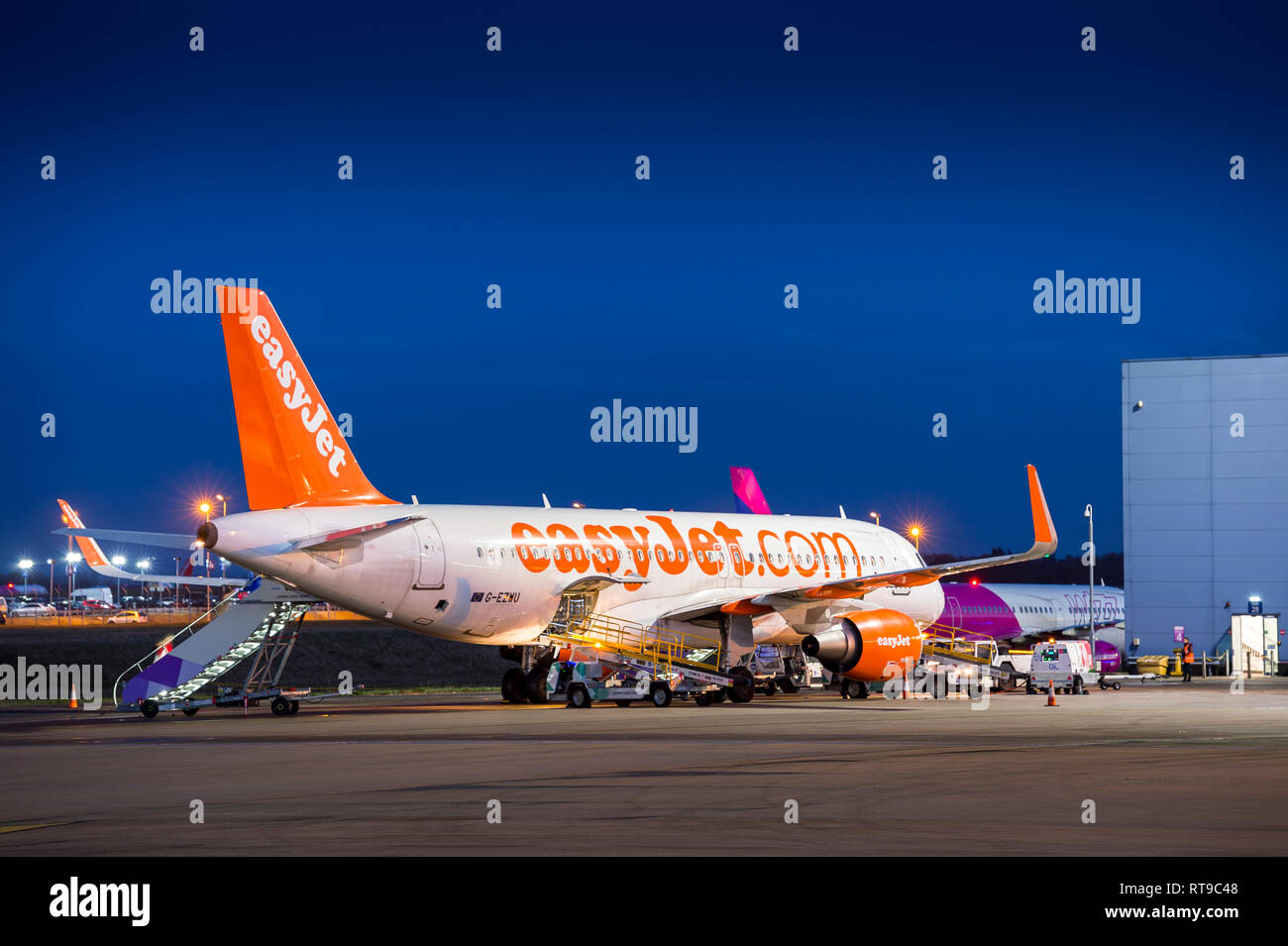 Easyjet aereo in attesa sull'area del piazzale di sosta al crepuscolo e all'aeroporto di Luton, Inghilterra. Foto Stock