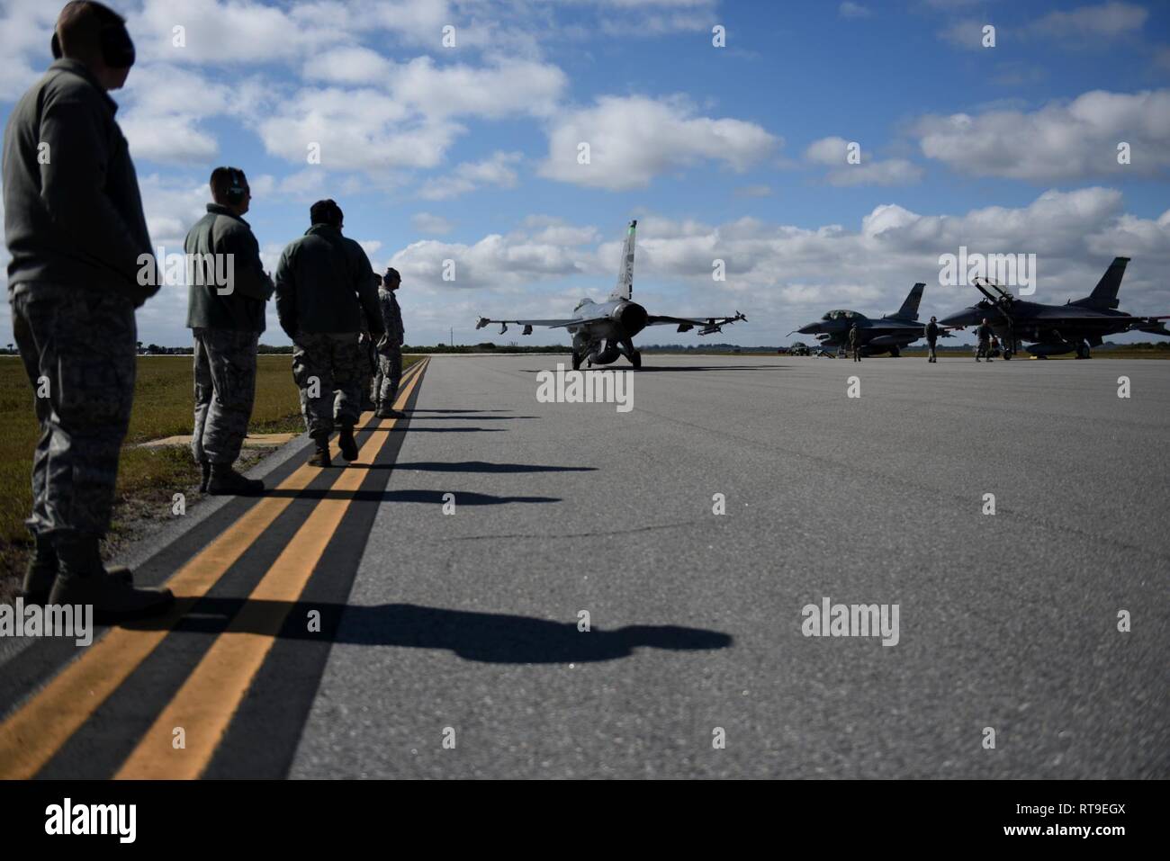Avieri dal centottantesimo Fighter Wing, Ohio Air National Guard, guardare come un F-16 Fighting Falcon i taxi per la pista prima di decollare a Patrick Air Force Base in Florida il 7 gennaio 28, 2019. Come parte della Patrick AFB di implementazione, il 180FW sarà condotta dissimile Air Combat Training, Basic Fighter manovre, aria difensivo contro le tattiche e tattiche di missioni di intercettazione a fianco F-15 Aquile assegnato alla 104th Fighter Wing, Barnes Air National Guard Base, Massachusetts. Foto Stock