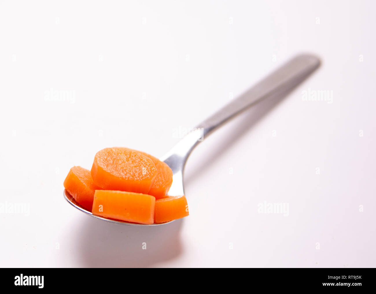 Un cucchiaio di cibo. La porzione di controllo. Carote cotte. Foto Stock