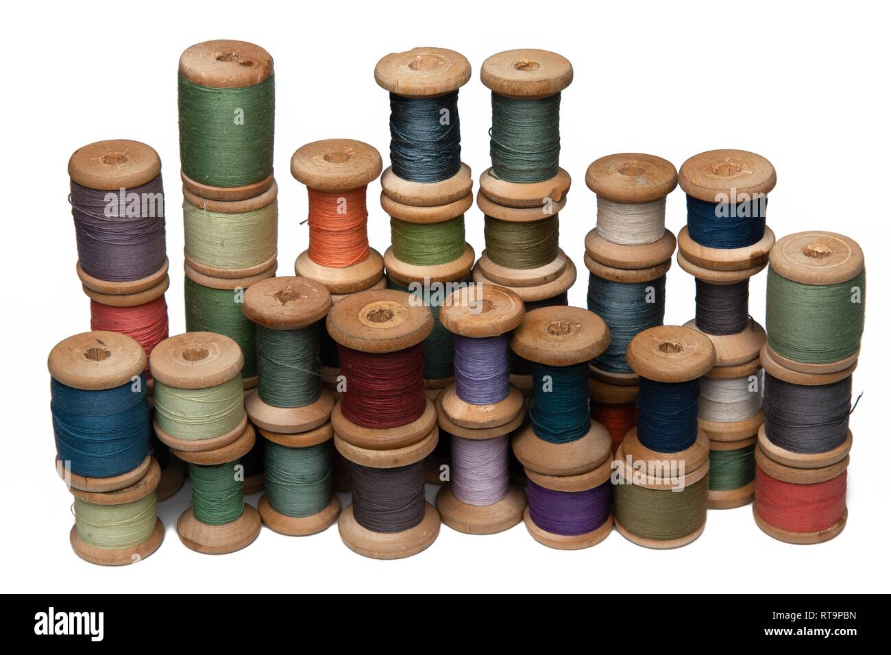 Bobine in legno con i fili colorati di colori pastello Foto Stock