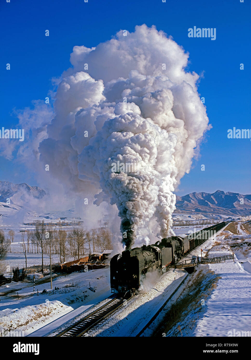 Due della classe QJ 2-10-2 locomotive a vapore trasporta un pesante treno merci in inverno a Jingpeng, Mongolia interna, la Cina nel gennaio 2005 Foto Stock