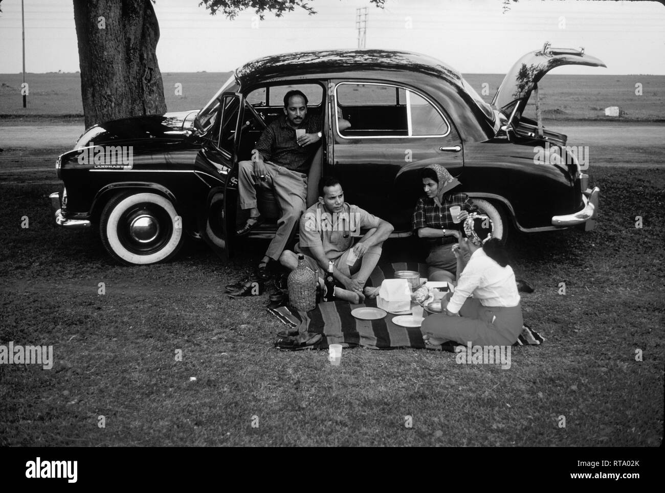 Le persone aventi un picnic con Hindustan Landmaster auto in India 1957 Foto Stock