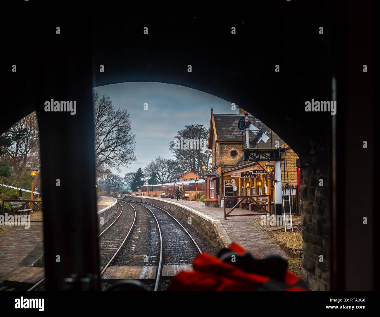 Treno conducente vista del pozzetto, dall'interno della cabina, attraverso la finestra di un treno in movimento sul patrimonio linea SVR, vintage imminente stazione ferroviaria, Arley. Foto Stock