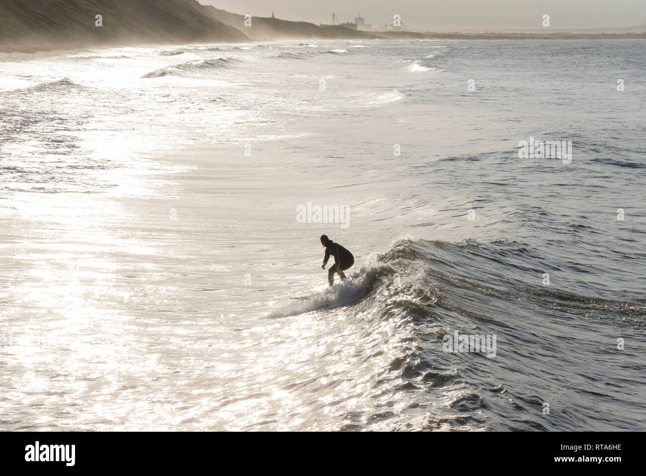 Giovane maschio surfer su un'onda a cambs, North Yorkshire, Inghilterra. Foto Stock