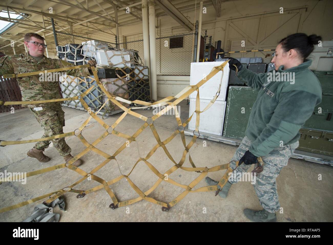 Stati Uniti Air Force Staff Sgt. Zackery Newton e Tech. Sgt. Tina Jaronik, sia con la cinquantanovesima Medical ala, districare cinghie durante la preparazione cargo pallet costruire fino a classe, Gennaio 31, 2019, a Kelly Field, Texas. La formazione militare permette ai membri la possibilità di apprendere e mettere in pratica le procedure corrette nella costruzione di pallet, eliminando gli errori a sostegno del mondo reale le contingenze. Foto Stock