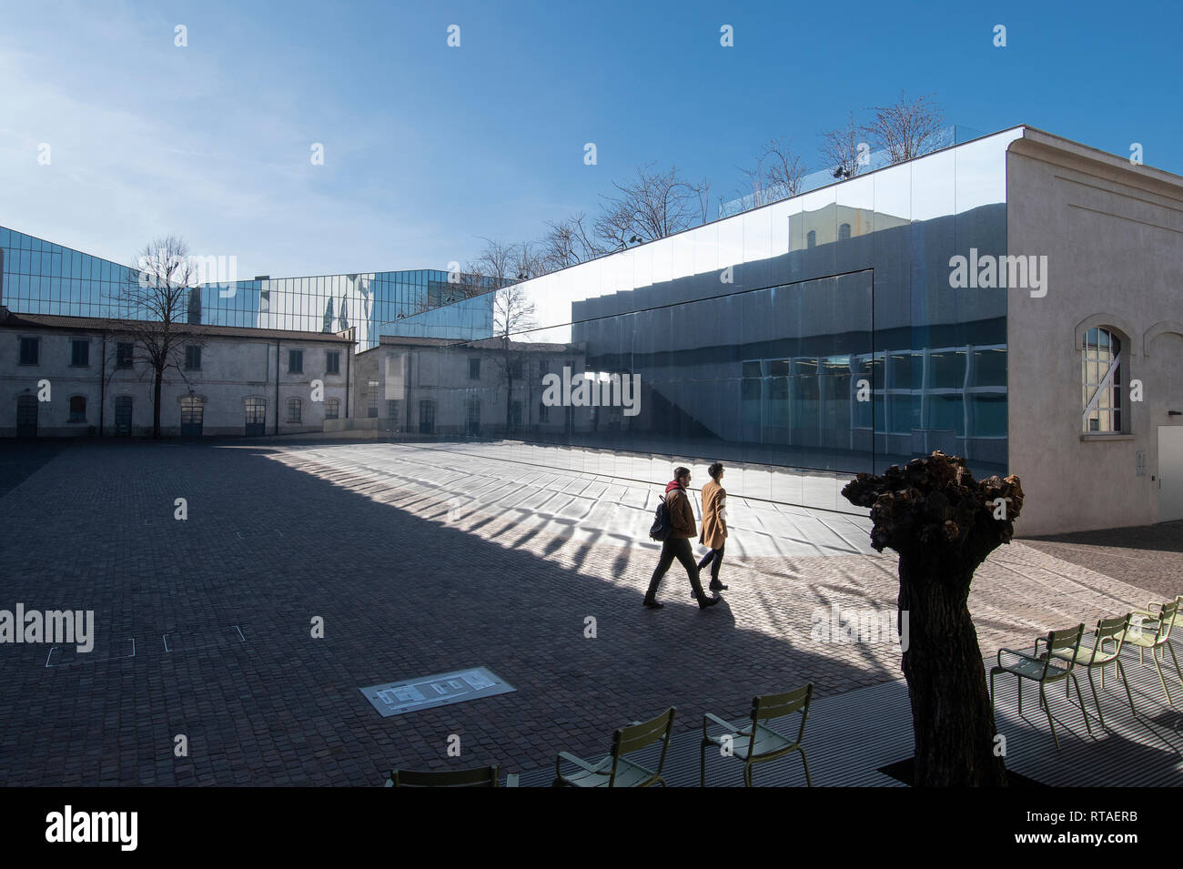 Due giovani a piedi attraverso uno dei cortili della Fondazione Prada, esterna, Milano, Italia Foto Stock