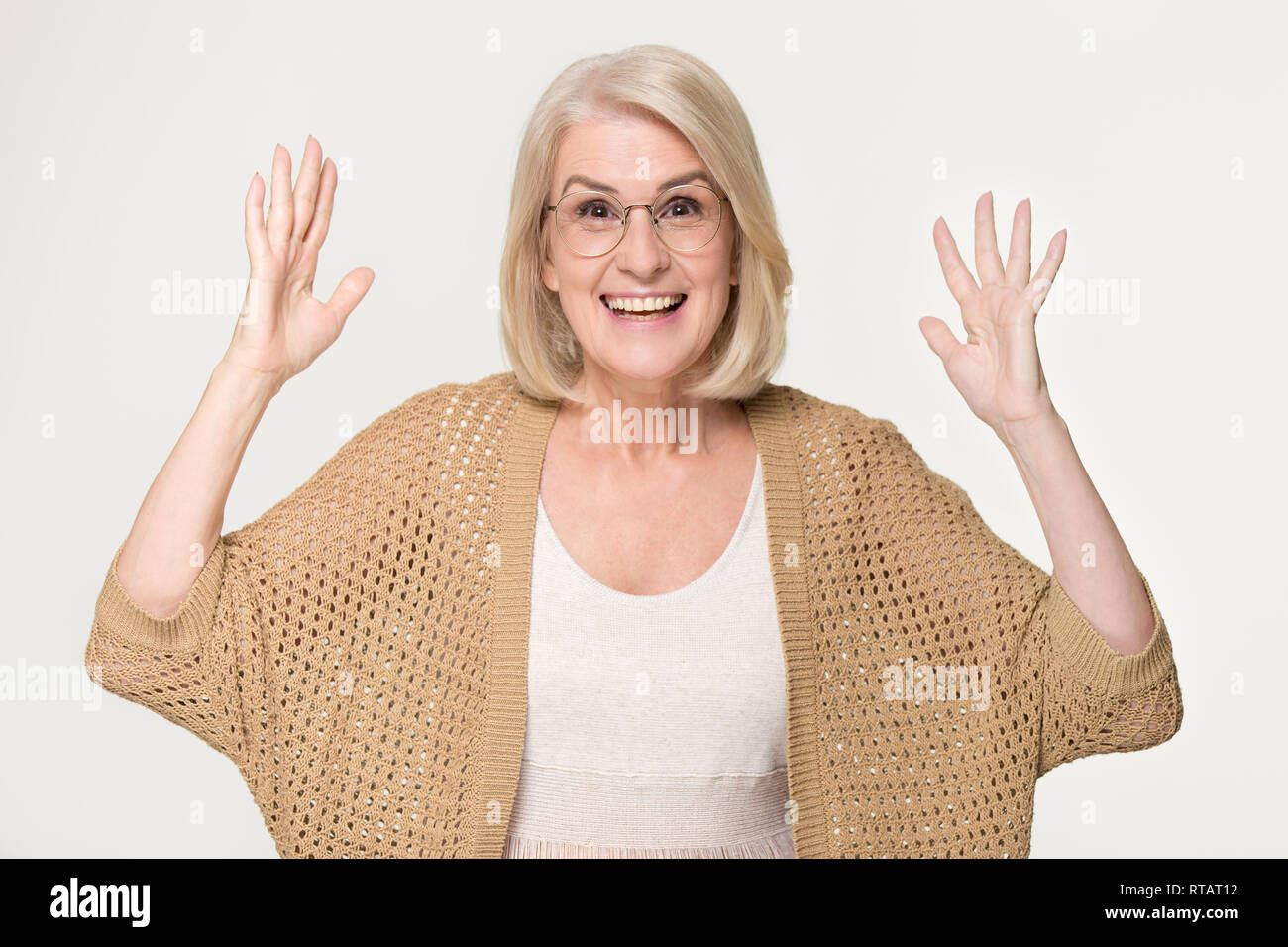 Excited donna matura sentirsi sorpreso isolato su sfondo grigio Foto Stock