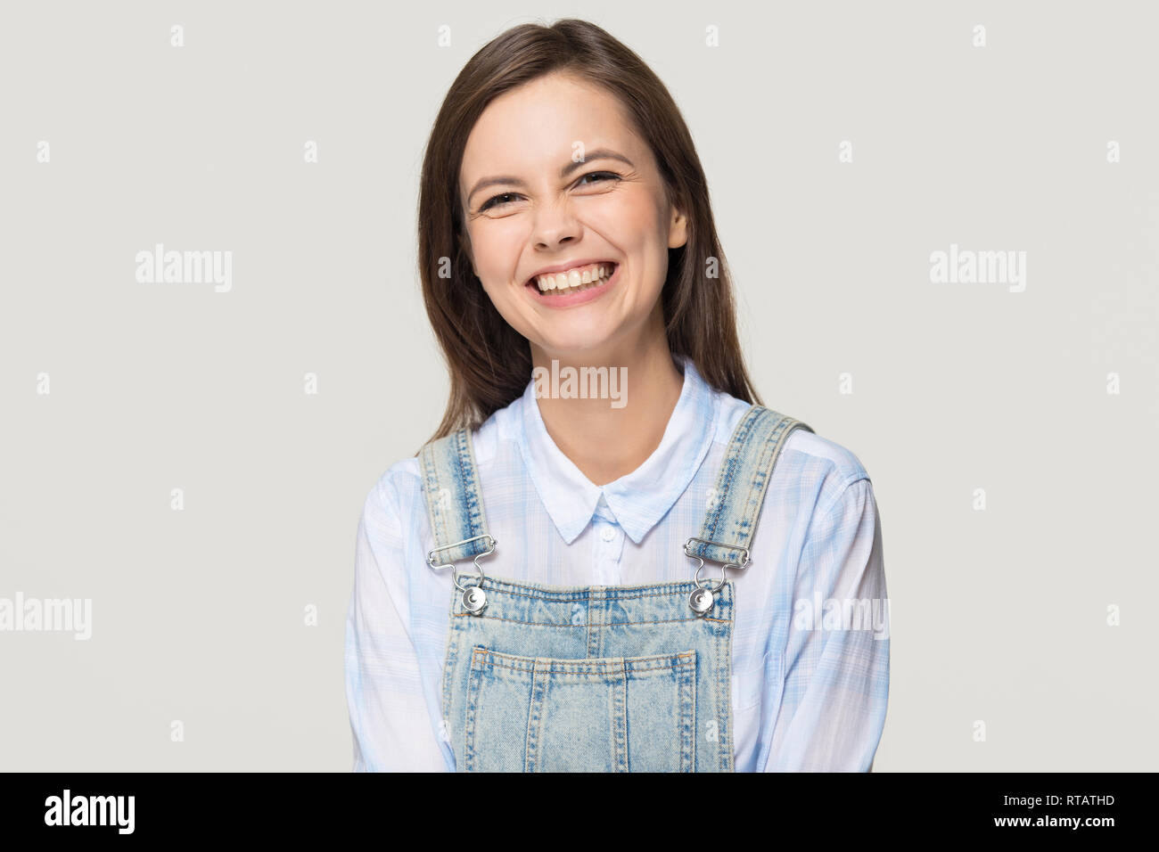 Felice una studentessa di ridere guardando la telecamera isolata su sfondo Foto Stock