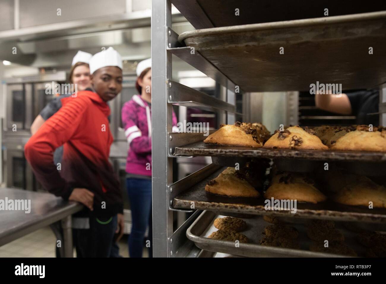 Morongo Unified School District studenti ispezionare un vassoio di beni cotti al forno a Phelps Hall, Marine Corps Air Ground Centro di combattimento, ventinove Palms, California, durante il combattimento Scuola centrale di collegamento 16 del lavoro annuale evento di shadowing, 6 febbraio 2019. Foto Stock