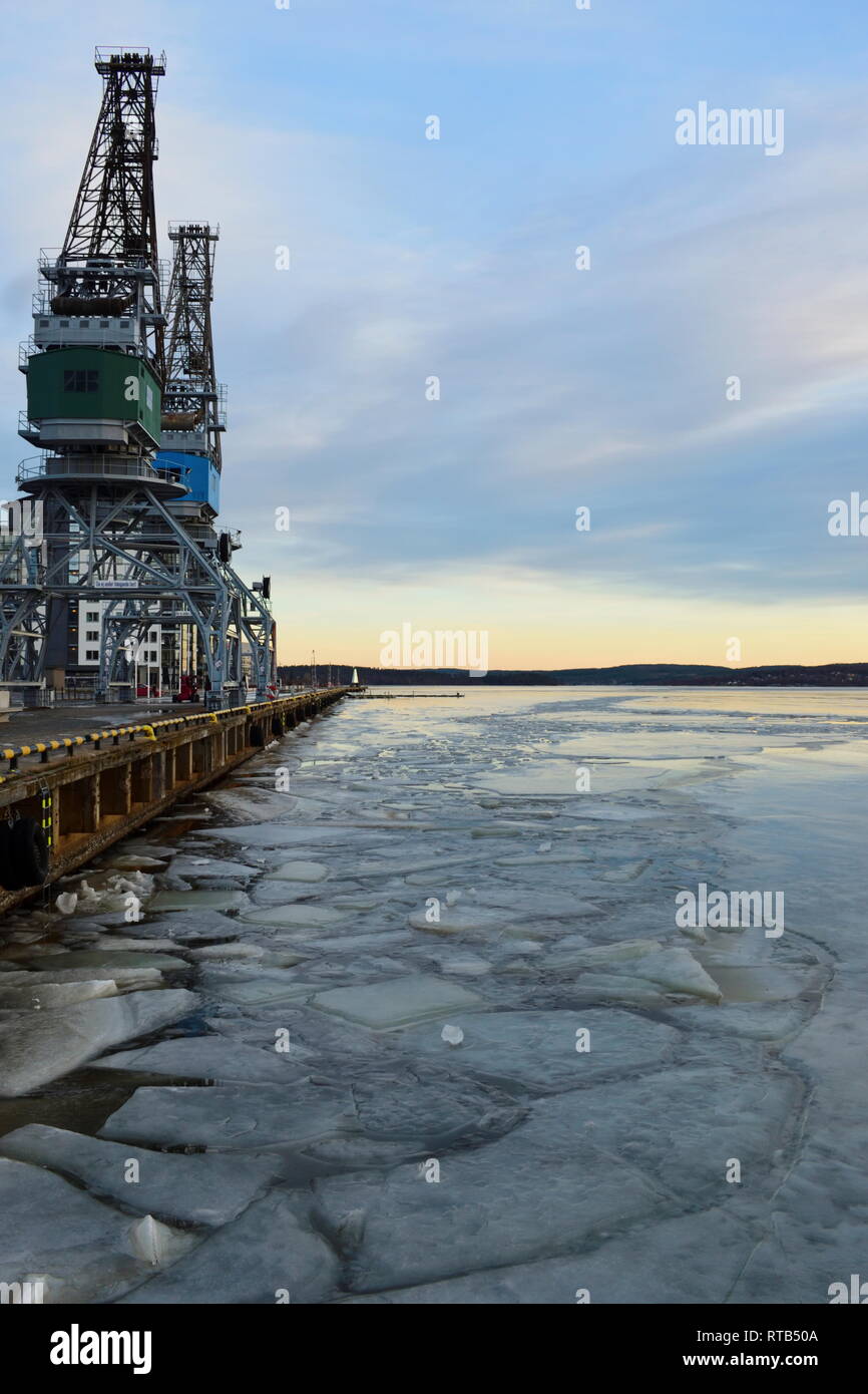 Ice floes sono flottanti su un vuoto che la baia del porto d'inverno. Foto Stock