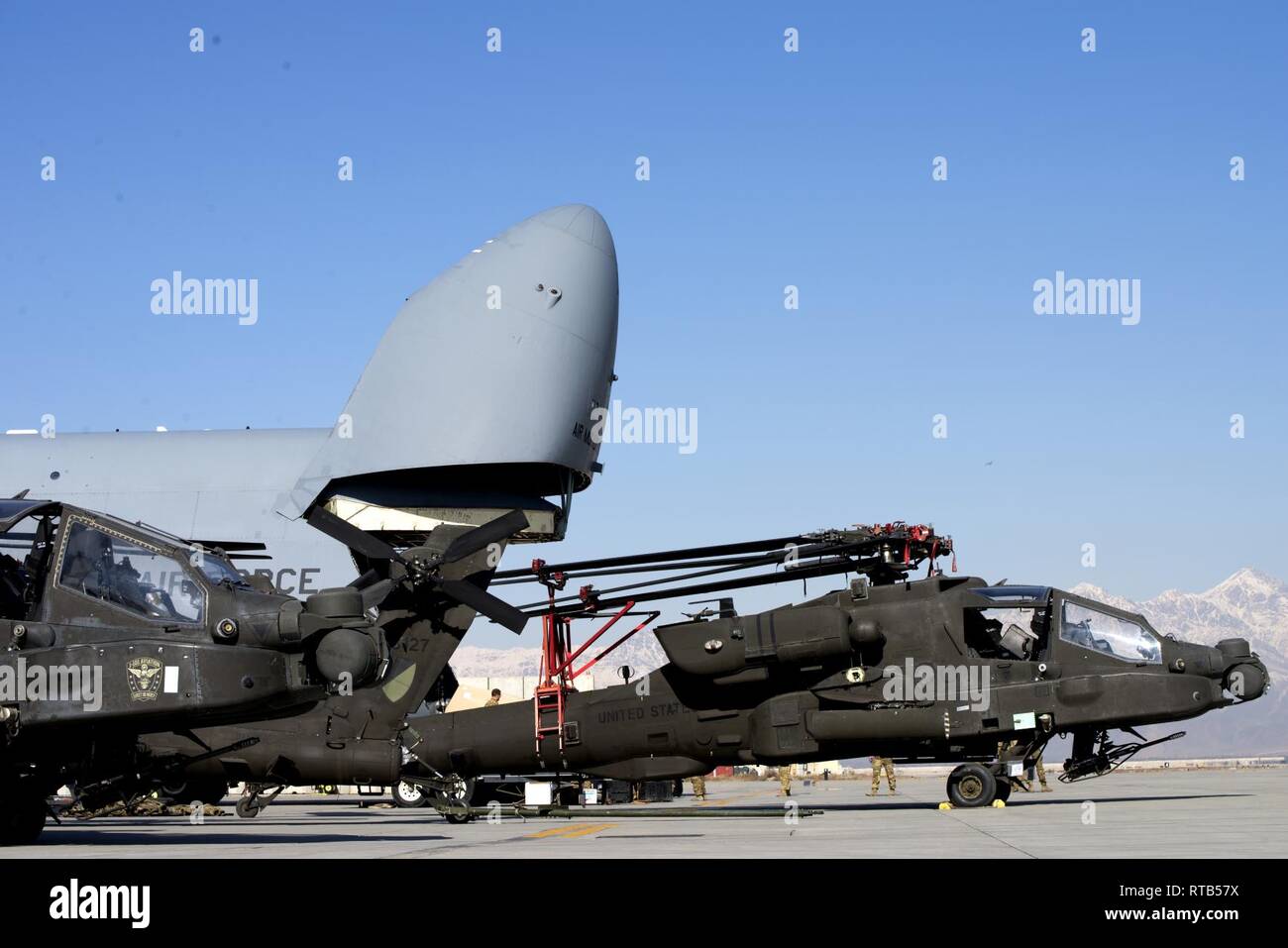 Avieri, soldati, e preparare il personale per caricare elicotteri Apache in un C-5 a Bagram Airfield, Afghanistan, nel febbraio 7, 2019. Il 455th Air Expeditionary Wing è composto da più di 2.100 aviatori si trova a Bagram, Jalalabad e Kandahar aerodromi. Foto Stock