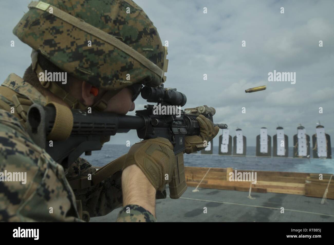 Lancia Cpl. Branik Brown, un leader di squadra con Bravo Company, Battaglione Team di atterraggio, 1° Battaglione, 4 Marines, incendi a M4 carbine durante la precisione di tiro della formazione in cima al ponte di volo del trasporto anfibio USS dock Green Bay (LPD 20), nel Mar della Cina orientale, Febbraio 2, 2019. Brown, nativo di La Mesa, California, Grossmont graduata di alta scuola in Jun., 2017, prima di arruolamento nel settembre 2017. Bravo è una società meccanizzata società raid con BLT 1/4, terra elemento di combattimento per la trentunesima Marine Expeditionary Unit. Il trentunesimo MEU, il Marine Corps' solo in modo continuo distribuita MEU partner Foto Stock