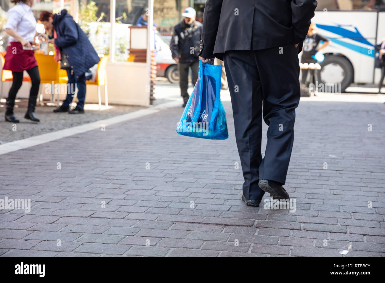 Febbraio 19, 2019. Atene Grecia, uomo blu hoding sacchetti di plastica. Vista ingrandita, spazio di copia Foto Stock