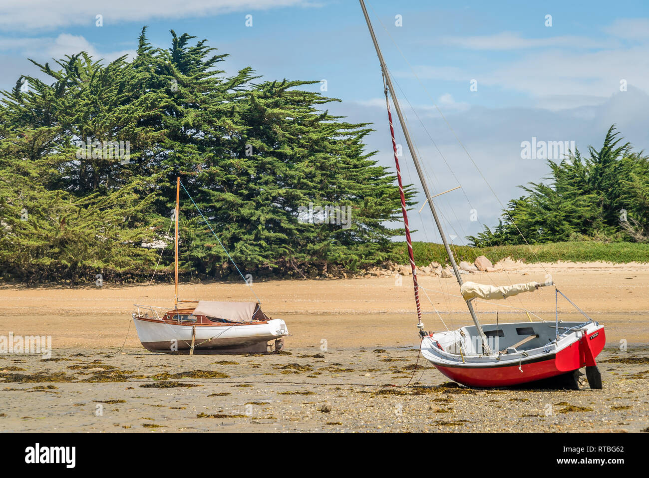 Piccole barche a vela da filamento e collegato a massa sulla spiaggia in Bretagna Foto Stock