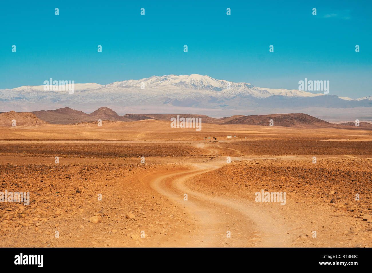 Vista pittoresca del percorso di campagna tra deserto selvaggio con terre e cieli blu a Marrakech, Marocco Foto Stock