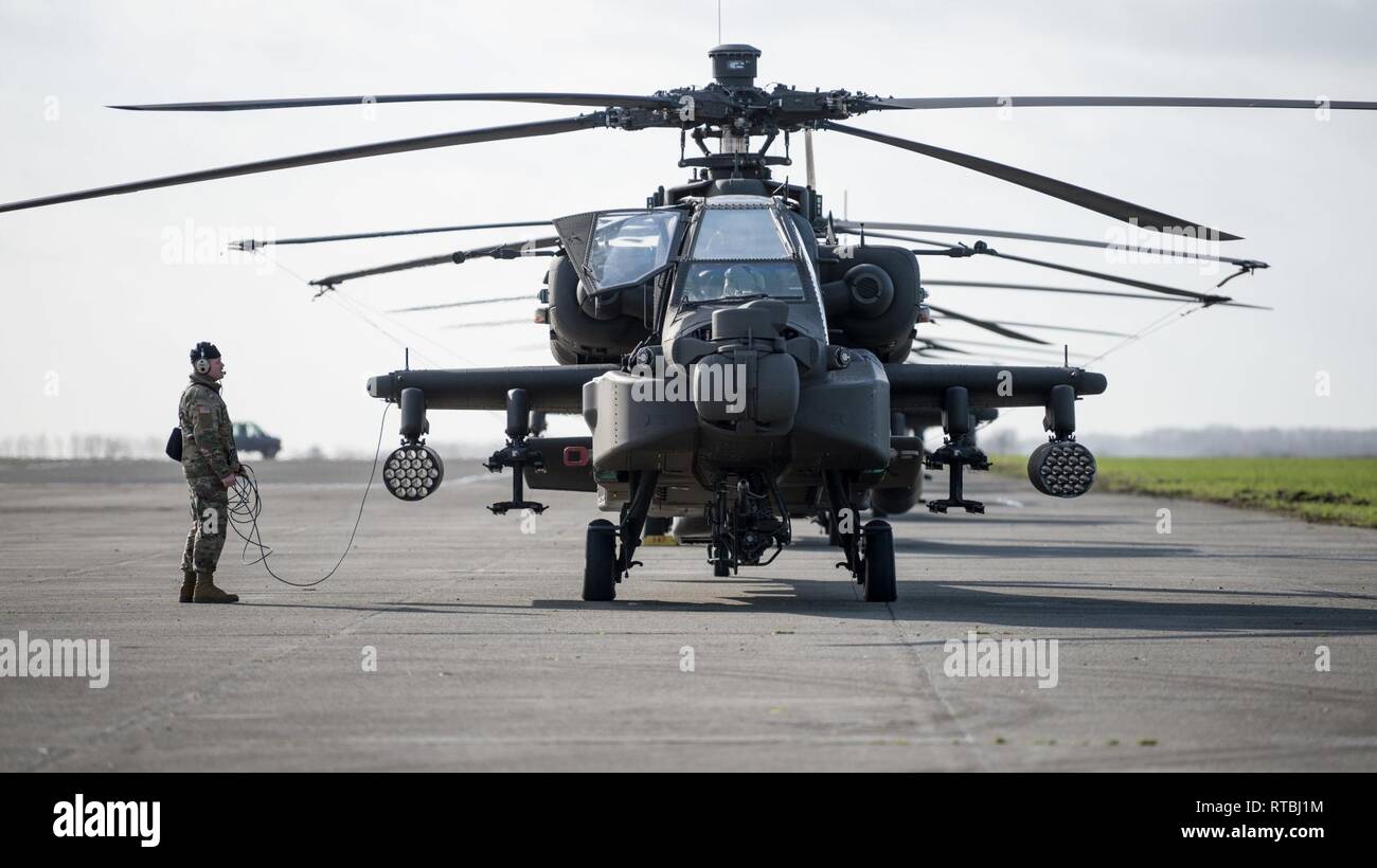 Un U.S. Massa dell'esercito membro di equipaggio del primo combattimento Brigata Aerea, 1a divisione di fanteria, contatti l'equipaggio di un AH-64 elicottero Apache, pronto a lasciare Wingene Air Base, Belgio, Febbraio 7, 2019. Wingene Air Base è servita come un intermedio area di sosta prima della 1a combattere la Brigata Aerea distribuisce in Germania, Polonia, Lettonia e Romania per nove mesi al treno con i partner della NATO a sostegno della Atlantic risolvere. Foto Stock