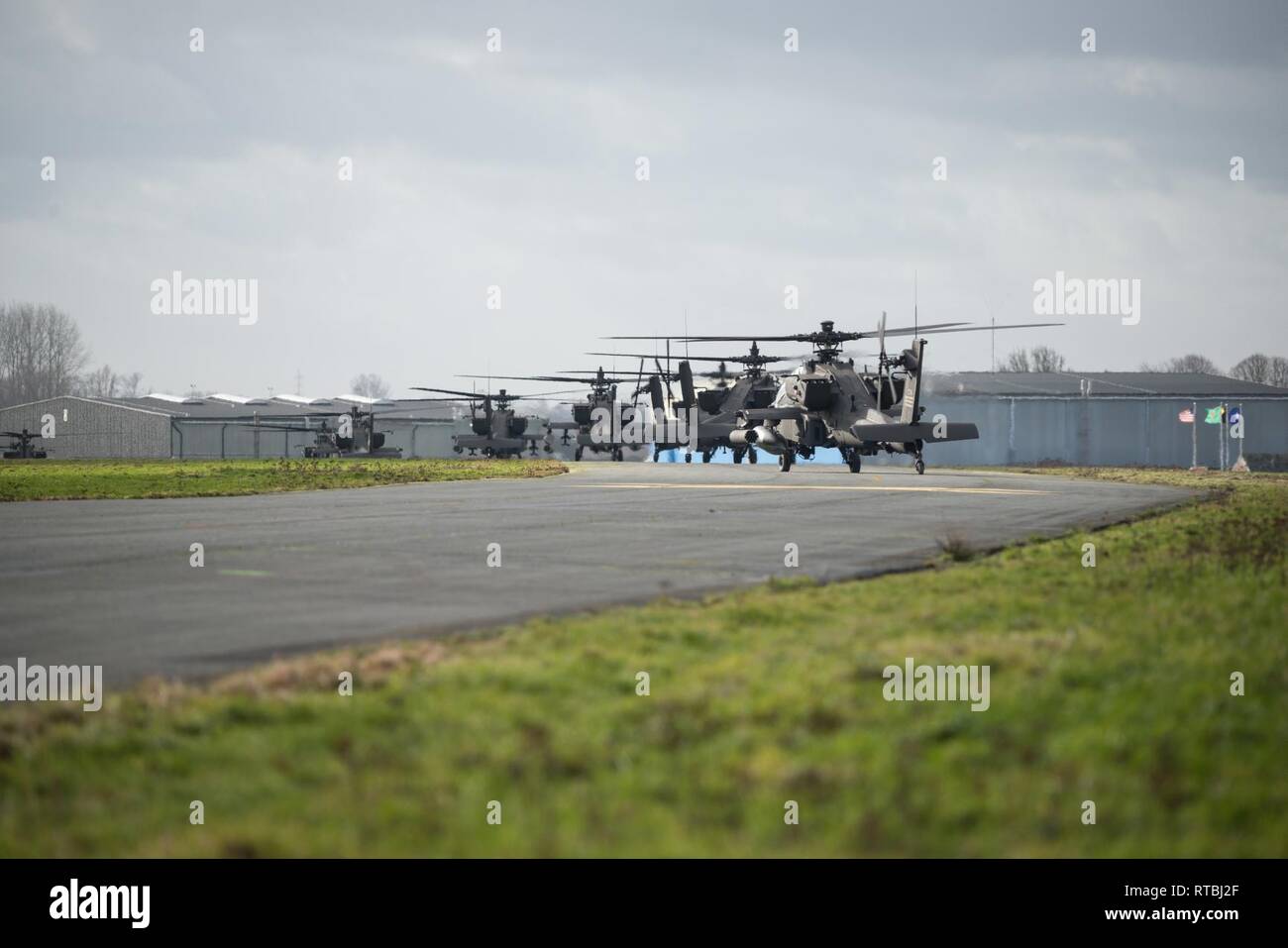 Stati Uniti Esercito AH-64 elicotteri Apache dal primo combattimento Brigata Aerea, 1a divisione di fanteria, lasciare Wingene Air Base, Belgio, Febbraio 7, 2019. Wingene Air Base è servita come un intermedio area di sosta prima della 1a combattere la Brigata Aerea distribuisce in Germania, Polonia, Lettonia e Romania per nove mesi al treno con i partner della NATO a sostegno della Atlantic risolvere. Foto Stock