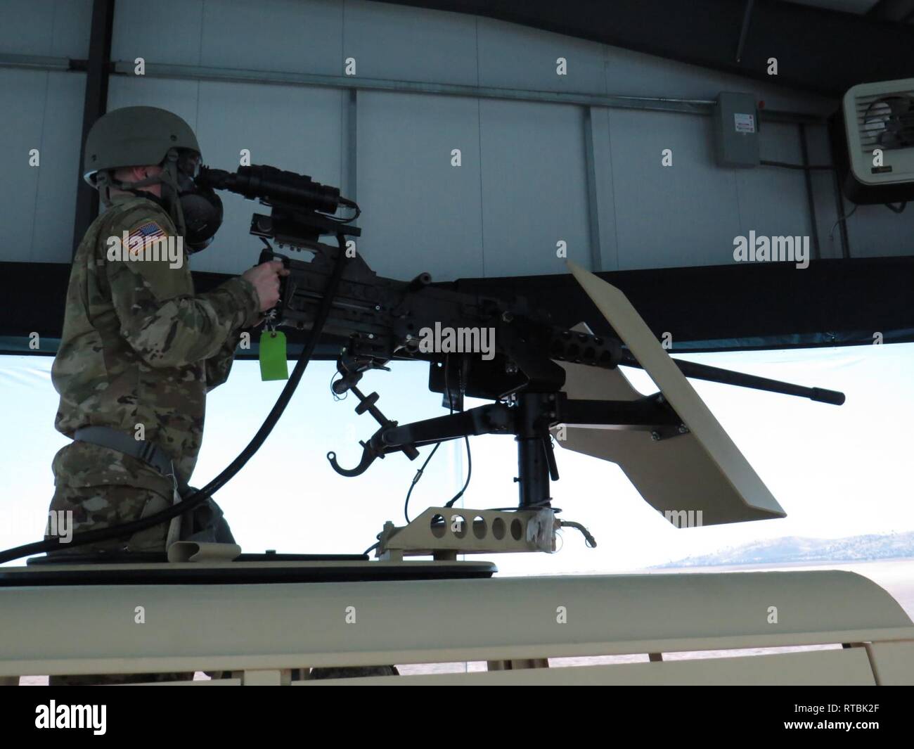 Un U.S. La riserva di esercito soldato indossando M40 campo Maschera di protezione incendi un pneumatico azionato M2 Browning 0,50 Caliber Browning machine gun nelle competenze del guerriero Trainer durante il funzionamento freddo acciaio III a Fort Hunter Liggett, California, 8 febbraio 2019. Treno di soldati come utilizzare sostanze chimiche equipaggiamento protettivo mentre impiega arsenale militare per preparare i potenziali attacchi chimici durante il tempo di guerra. Il funzionamento freddo acciaio III treni e si qualifica la riserva di esercito di soldati sulla M2 .50 mitragliatrici calibro, M19 40 mm automatico di lanciagranate e M240 7,62 mm mitragliatrici sistemi di armamenti in terra e mount Foto Stock