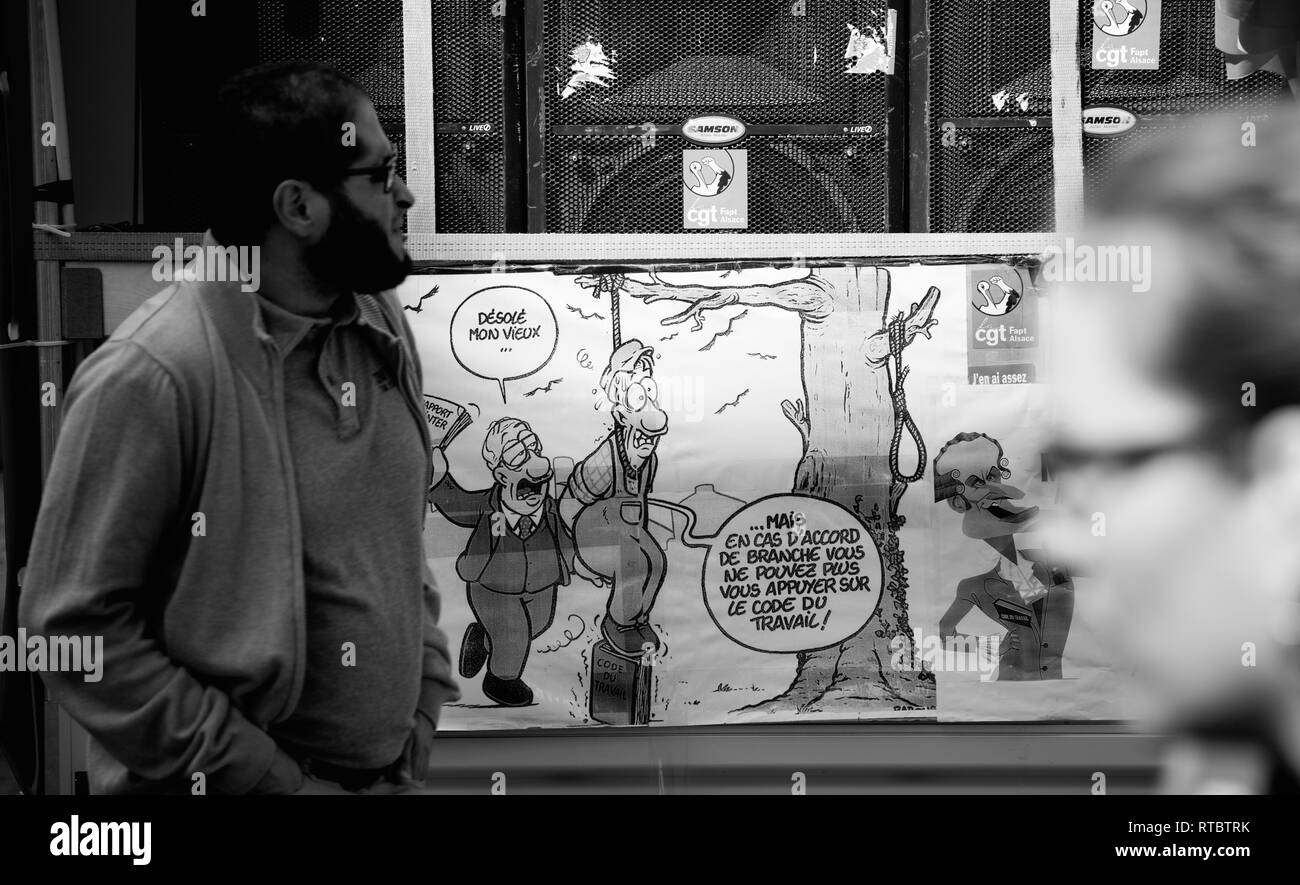 Strasburgo, Francia - Settembre 12, 2017: uomo a camminare nei pressi di anti-Macron caricatura francese giornata nazionale di protesta contro la riforma del lavoro proposto da Emmanuel Macron di governo Foto Stock