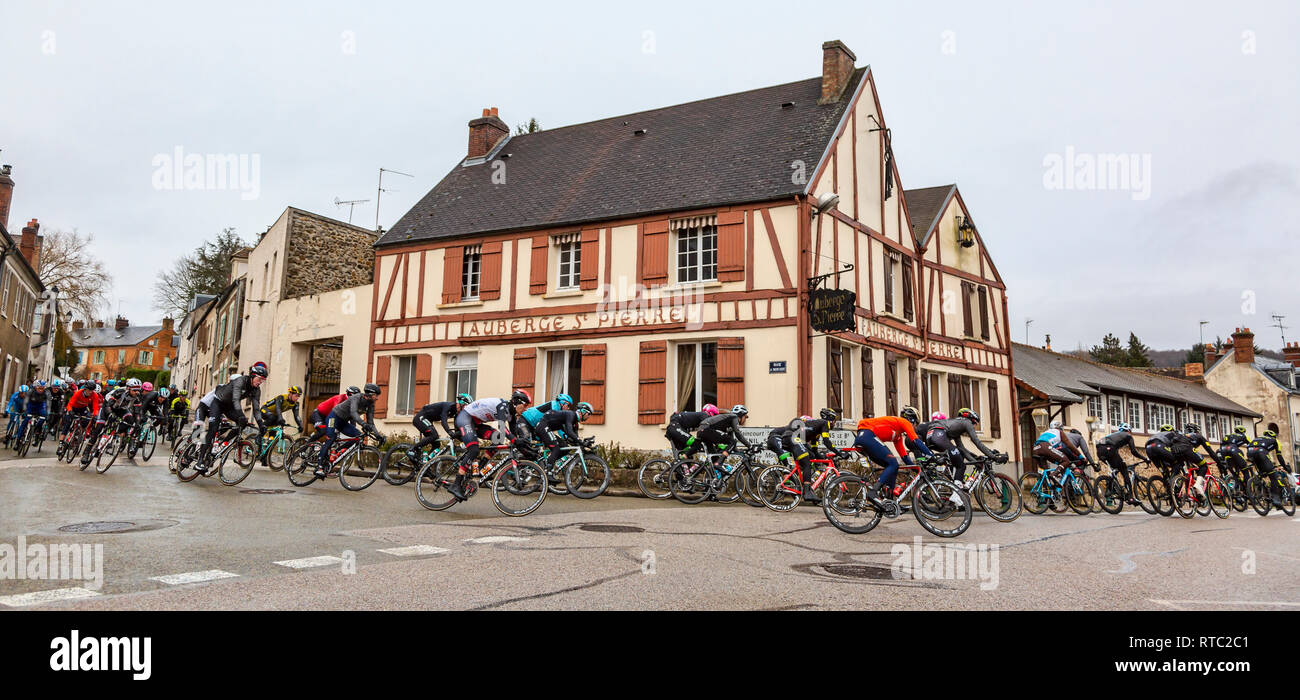 Dampierre-en-Yvelines, Francia - 4 Marzo 2018: Il Peloton passa davanti ad edifici tradizionali su una piccola strada in un villaggio francese durante la pari Foto Stock