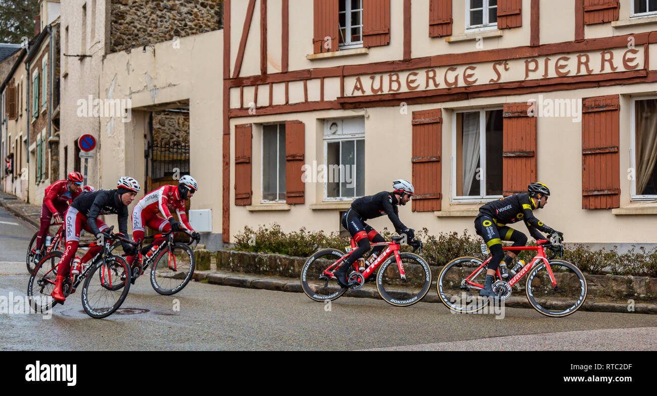 Dampierre-en-Yvelines, Francia - 4 Marzo 2018: il gruppo dei ciclisti e gite in carrozza nella parte anteriore di edifici tradizionali su una piccola strada in un villaggio francese durante Foto Stock