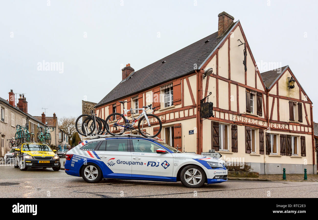 Dampierre-en-Yvelines, Francia - 4 Marzo 2018: la tecnica di auto Groupama-Team FDJ passando davanti ad una tradizionale francone house durante il Foto Stock