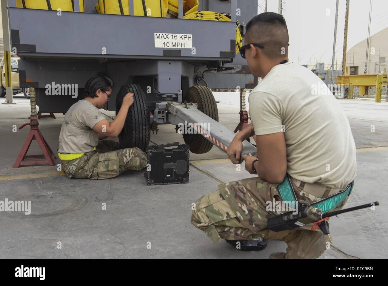 Airman 1. Classe Mia Duran, 380 Manutenzione Expeditionary Squadron Aerospace Ground Equipment tecnico, sostituisce un pneumatico sul TLD unità aria condizionata mentre Senior Airman Andyhoang Vu. 380 EMXS tecnico di età, lo mantiene in posizione, 11 febbraio, 2019, al Dhafra Air Base, negli Emirati Arabi Uniti. Il loro giorno per giorno la missione è di mantenere tutte le apparecchiature qui e sul nostro volo di linea per assicurarsi che la missione pronto ogni volta che l'aeromobile ne ha bisogno. Foto Stock