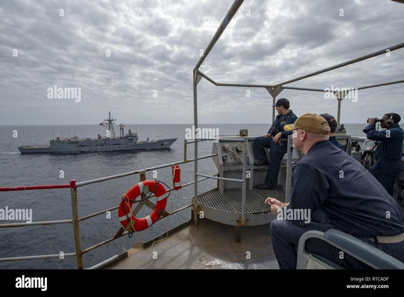 Stati Uniti 5TH FLOTTA AREA DI OPERAZIONI (feb. 12, 2019) - Cmdr. Steve Schmidt, comandante della Whidbey Island-classe dock anfibio sbarco nave USS Fort McHenry (LSD 43) osserva come la marina militare egiziano guidate dell-missile frigate Alessandria (FFGH 911) passa Fort McHenry durante il passaggio di un esercizio. Fort McHenry è parte dell'anfibio Kearsarge pronto il gruppo e con il ventiduesimo imbarcato Marine Expeditionary Unit, è distribuito negli Stati Uniti Quinta Flotta area di operazioni a sostegno di operazioni navali per garantire stabilità marittimo e la sicurezza nella regione centrale di collegamento del Mediterraneo e th Foto Stock