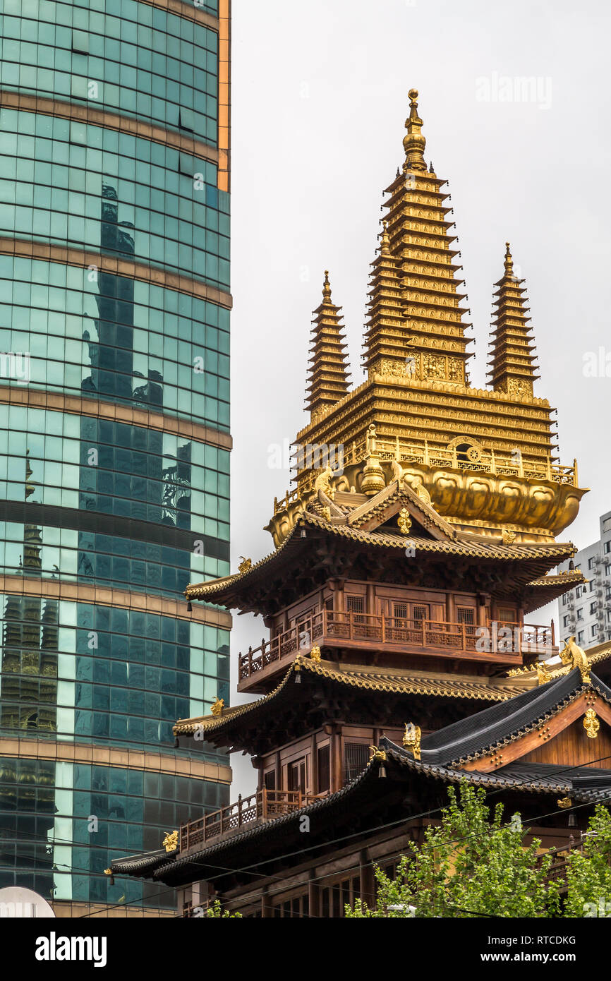 Il Jing' un tempio o tempio di pace e tranquillità con la sua vistosamente decorata e dorata torre sorge giustapposti con il grattacielo dietro. Foto Stock