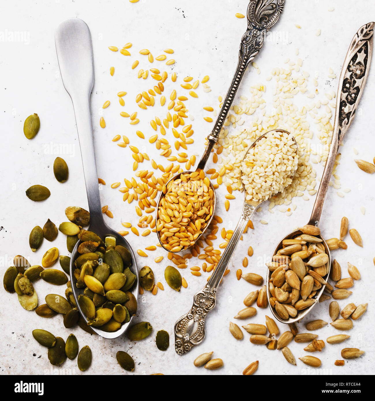 I semi di lino, di sesamo, di girasole e di zucca in cucchiai d'argento su  un tavolo, la vista superiore Foto stock - Alamy