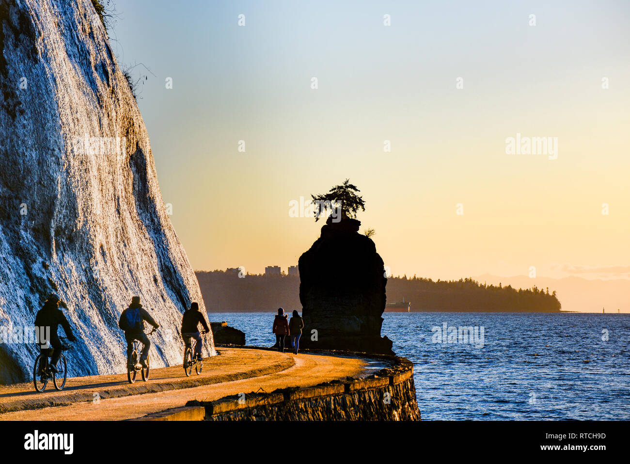 I ciclisti vicino Siwash Rock, Stanley Park, seawall, Vancouver, British Columbia, Canada Foto Stock