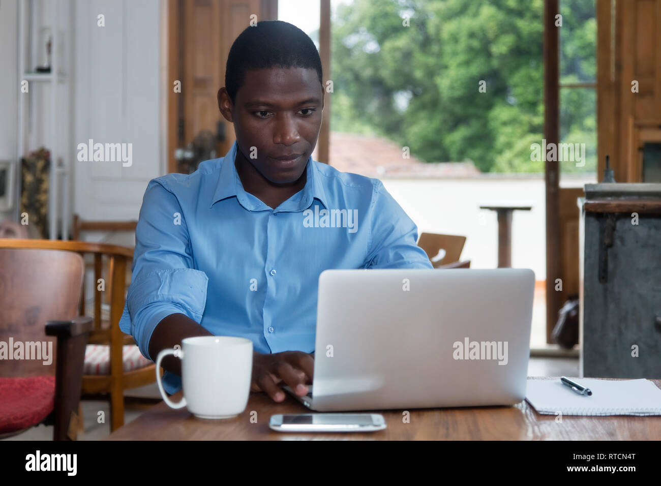 Lavoro duro americano africano uomo con il portatile a casa alla scrivania Foto Stock