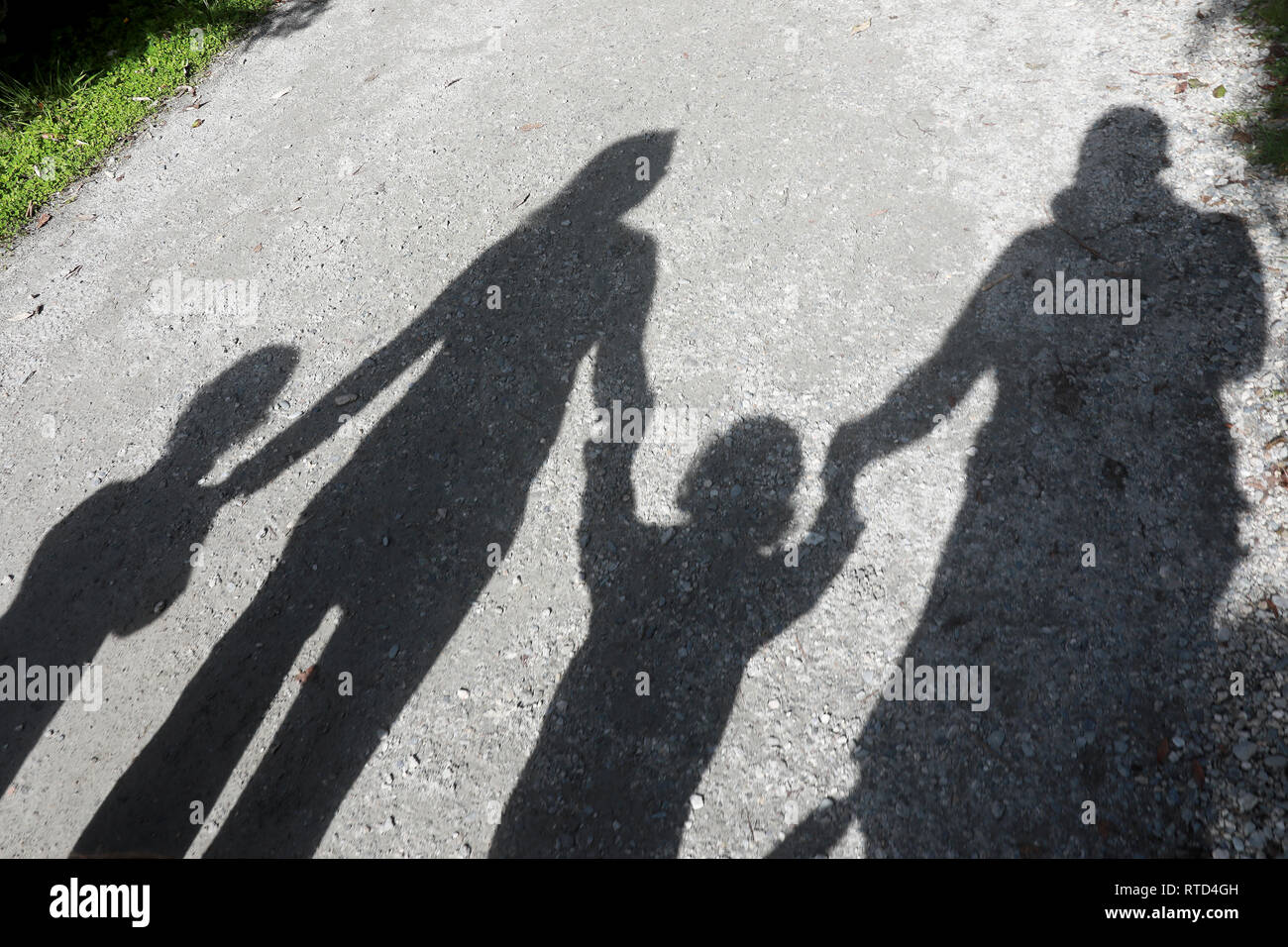 Ombra della famiglia di quattro camminando sul sentiero di ghiaia sentiero Ghiacciaio Franz Josef percorso Nuova Zelanda Isola del Sud Foto Stock