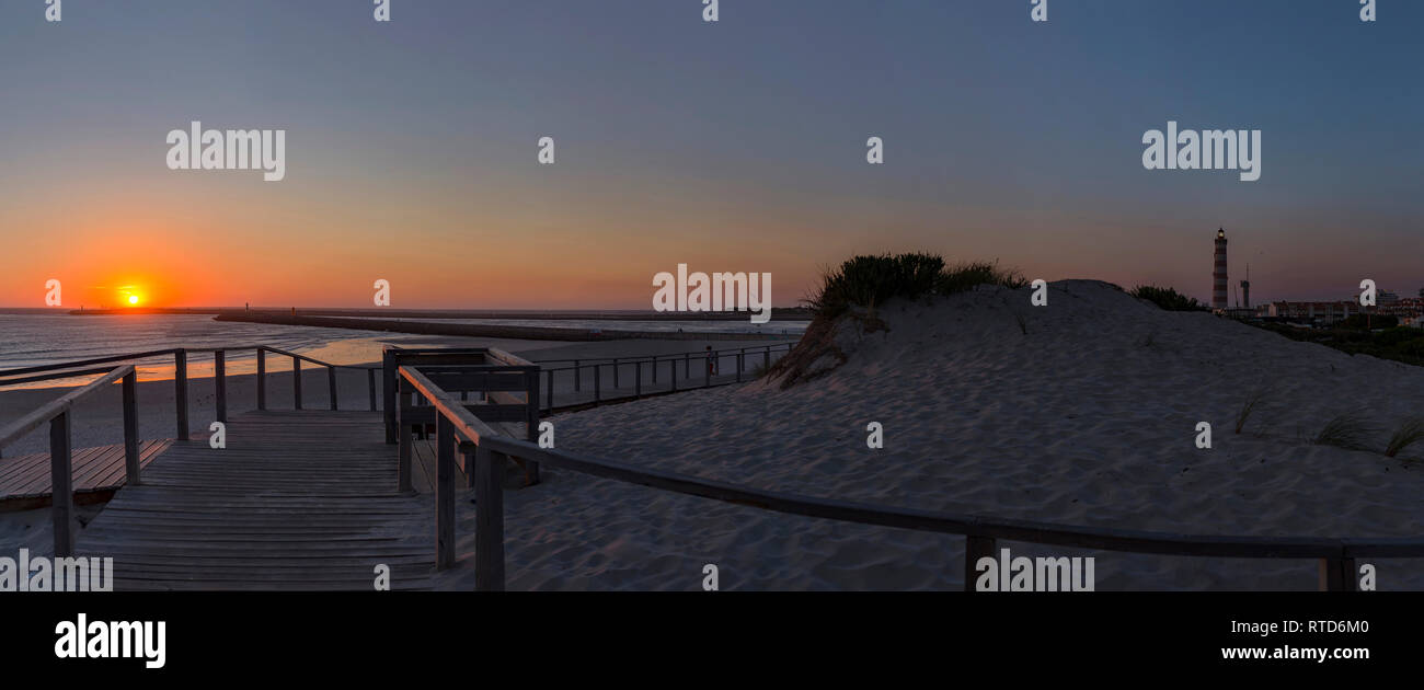 Tramonto, Praia do Paredão, Farol da Barra, la spiaggia e il faro, Praia da Barra, Aveiro, Portogallo Foto Stock